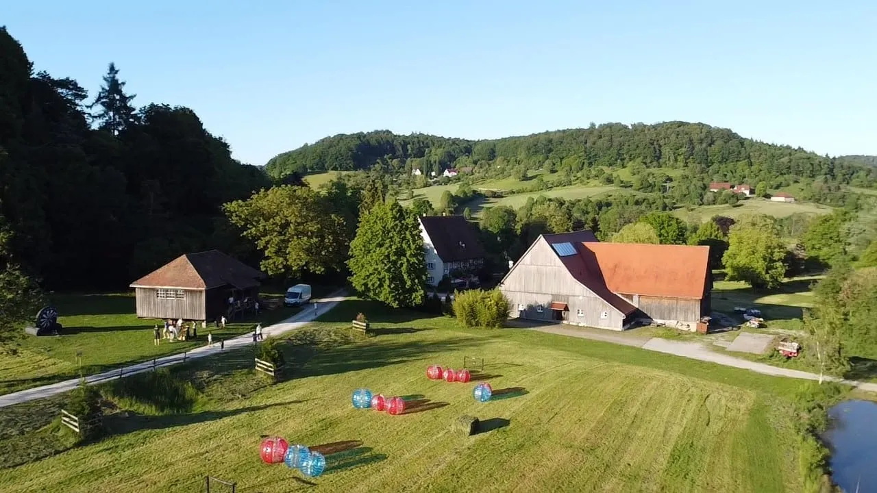 Drohnenaufnahme des Baierbacher Hofs mit Bubble-Soccer-Bällen auf der Wiese